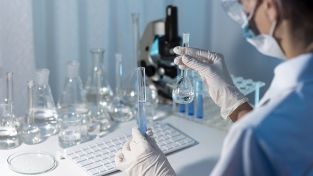 Researchers holding glassware in the learning lab